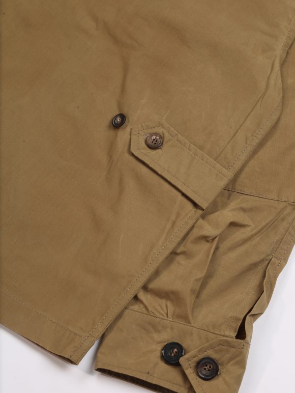 Close-up of the TARGA Jacket in beige waxed cotton showing adjustable button cuffs and natural waxed fabric texture.