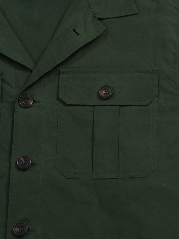 Close-up of the olive waxed cotton TARGA Jacket showing the pleated flap chest pocket and horn-style buttons.