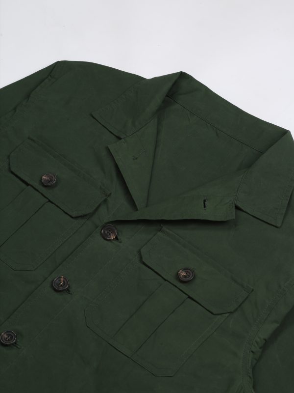 Detail of the olive waxed cotton TARGA Jacket showing the open collar, button closure and pleated chest pockets.